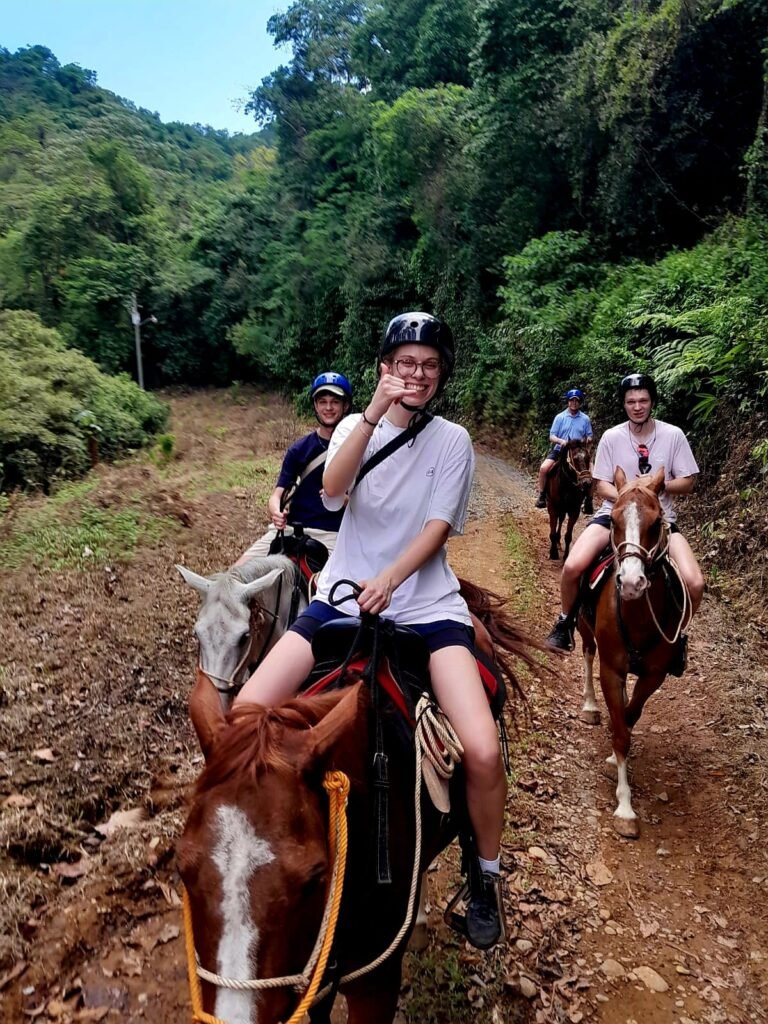 Family of four riding on a Volcano Tenorio foothills during a Rio Celeste tour ascending to a scenic plateau